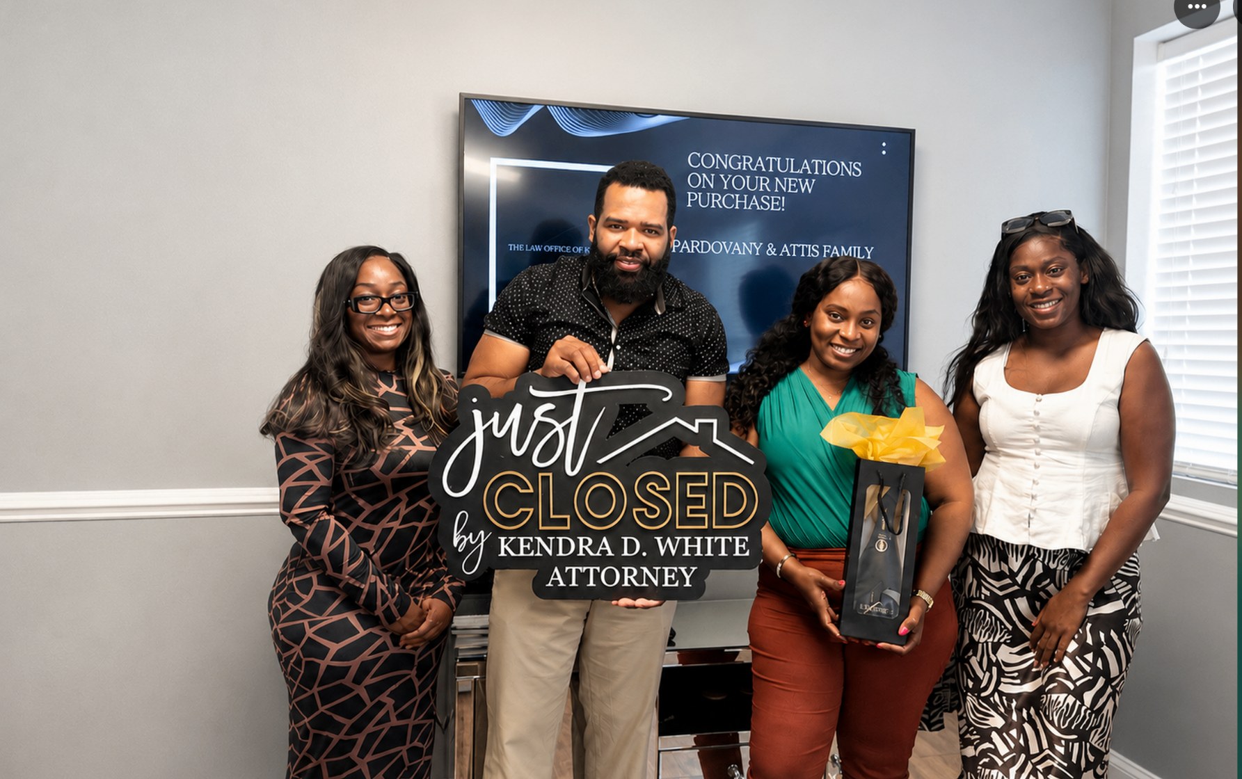 Buyers celebrating with a Just Closed sign at their home purchase closing